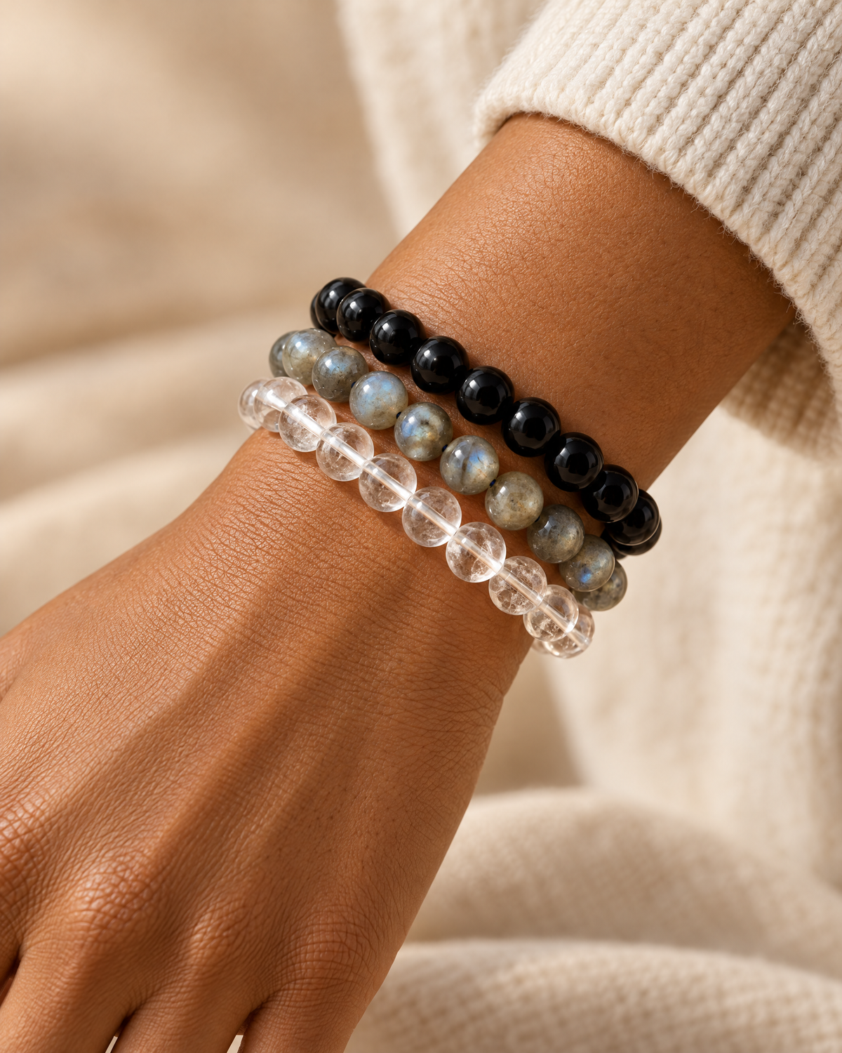 Brown-skinned model wearing The Grounded Protection Stack with Black Obsidian, Labradorite and Clear Quartz bracelets